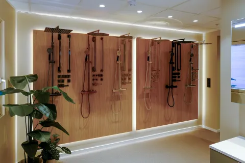 Utstillingsvegg med dusjsett i flere finisher