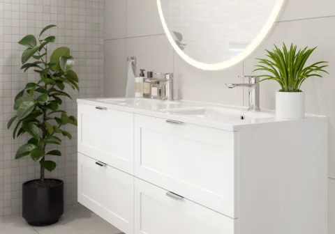 Hvitt vegghengt servantskap med rammefront, dobbel servant og rundt speil med lys